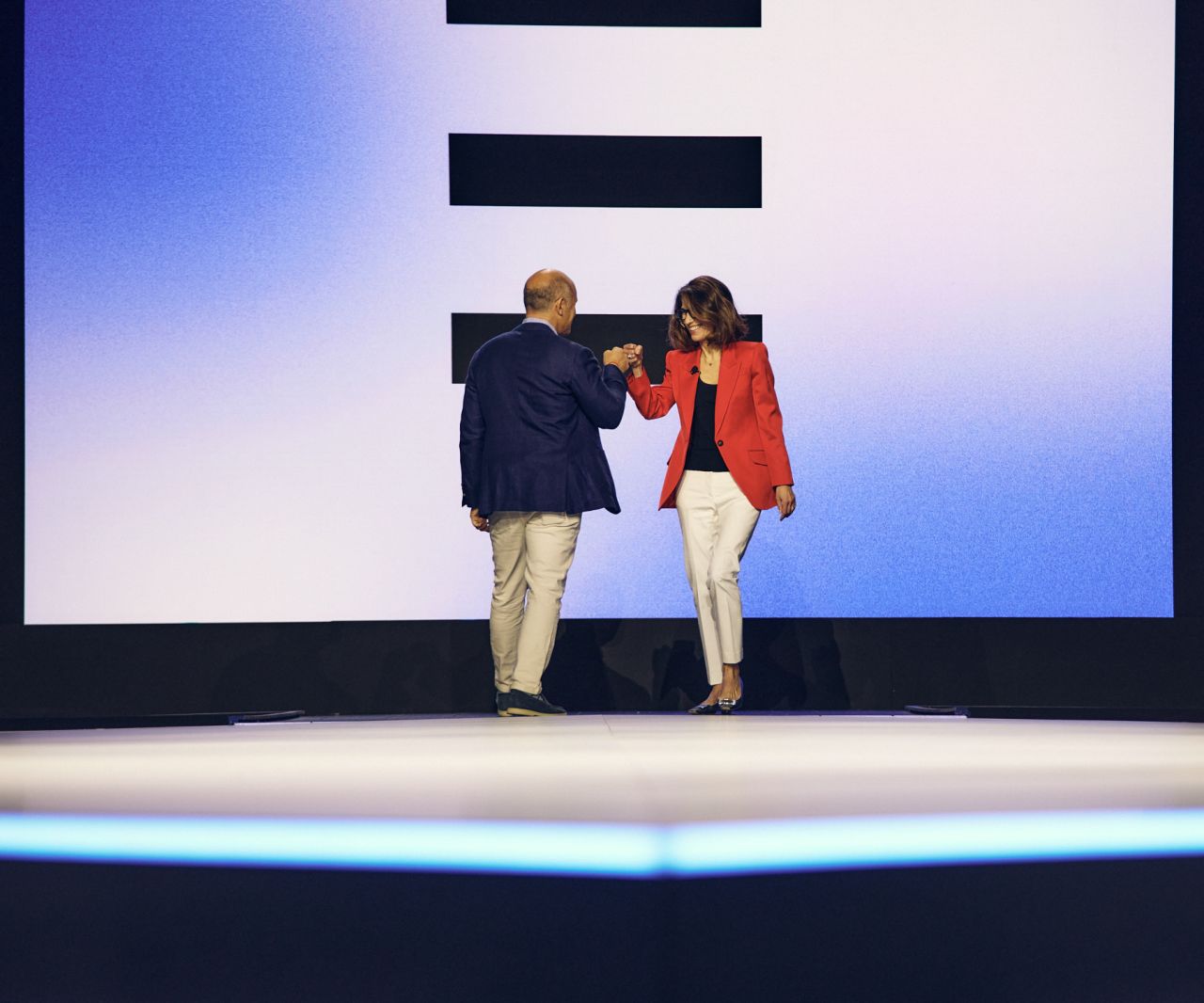 Two leaders fist-bump on the Expedia stage